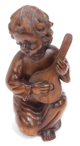 A continental carved hardwood figure, of a young child playing a mandolin, 66cm high.