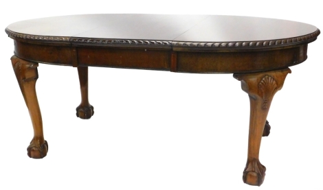 An early 20thC mahogany extending dining table, the oval top with a rope twist carved border, on bulbous and heavy cabriole legs, with ball and claw feet headed by shell carving, 73cm high, the top 105cm x 177cm.