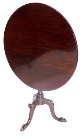 A mahogany tilt top table in George III style, the circular top on a turned part fluted column, on leaf carved cabriole legs with ball and claw feet, 85cm diameter.