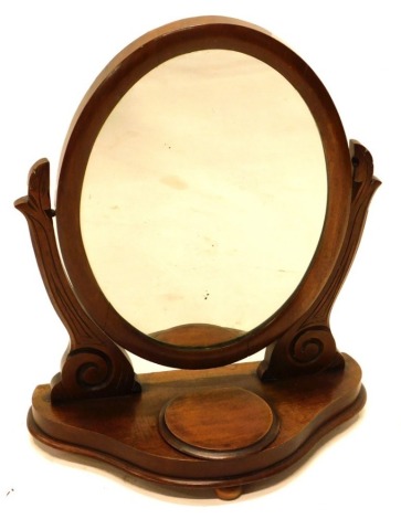 A Victorian mahogany dressing table mirror, the oval plate on shaped supports, a shaped base with a hinged trinket compartment, 49cm wide.