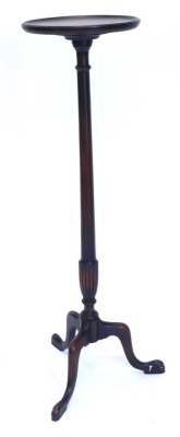 A mahogany plant stand or torchere, circular dished top on a turned part fluted column, with tripod base, 107cm high.