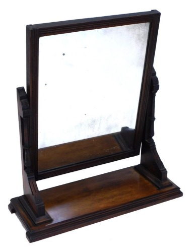 A Victorian walnut aesthetic movement dressing table mirror, the rectangular plate with a reeded border on part turned supports, on a stepped base, 68cm wide.