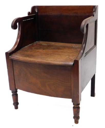 A 19thC mahogany commode, the raised back, scroll carved arm supports above a hinged seat, enclosing a recess on turned legs, 54cm wide.