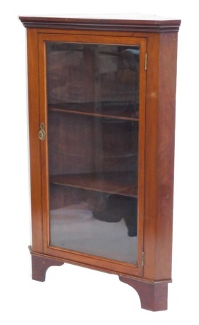 A mahogany standing corner cabinet, with a single glazed door on bracket feet, 81cm wide.