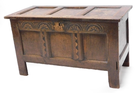 A late 17th/ early 18thC oak panelled coffer, with a frieze carved with arches above an ebonised inlay flanking the three panels, on styled feet, 61cm high, 106 wide.