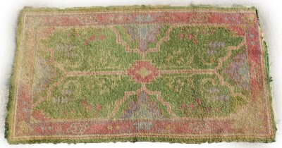 A Turkish rug, with a central pink pole medallion on a green ground, with one wide and multiple borders, (AF), 98cm x 174cm.