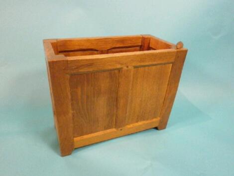 An oak magazine rack by Peter "Rabbit Man" Heap with panelled sides on stiles