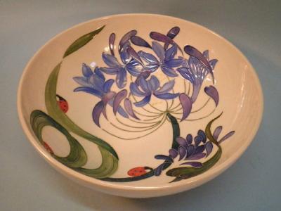 A modern Moorcroft bowl decorated with ladybirds and purple flowers