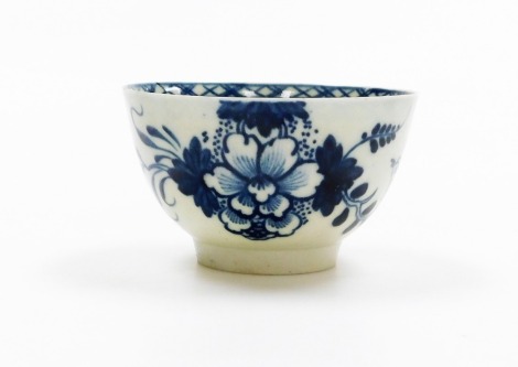 An early Liverpool porcelain tea bowl, probably Pennington, c1780, with blue chequered border and flowered detailing with birds, 8cm diameter.