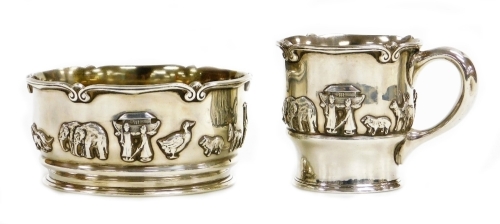 A George V silver christening set, with bowl and tankard, each decorated with Noah's Ark figures, stamped Barrett and Sons of Piccadilly, Birmingham import marks 1924, the bowl 1922, the tankard 7cm high, the bowl 11cm wide, 10¼oz.