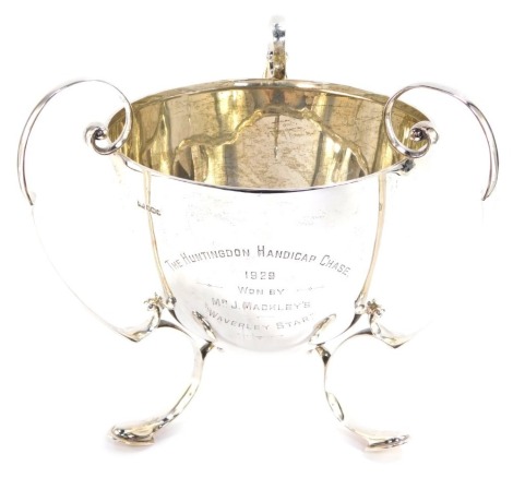 A George V silver trophy, presentation engraved The Huntingdon Handicap Chase 1929, Won By Mr J Mackley's 'Waverley Star', with triple scroll handles, raised on conjoined scroll feet, Walker & Hall, Sheffield 1928, 50.8oz, 27cm high.