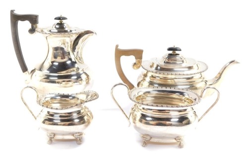 An Elizabeth II silver four piece tea and coffee set, London shape, with a gadrooned rim, and raised on four paw feet, comprising tea pot, coffee pot, cream jug and sugar bowl, Viners Ltd, Sheffield 1957, 64.12oz.