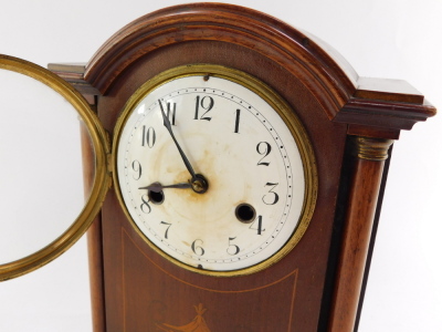 A late Victorian mahogany and inlaid mantel clock, circular enamel dial bearing Arabic numerals, German eight day movement, with coil strike, the case of domed architectural form, with brass capped columns, raised on a plinth base, on bun feet, with pendu - 2