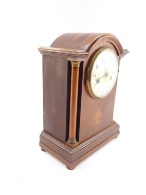 A late Victorian mahogany and inlaid mantel clock, circular enamel dial bearing Arabic numerals, German eight day movement, with coil strike, the case of domed architectural form, with brass capped columns, raised on a plinth base, on bun feet, with pendu - 3