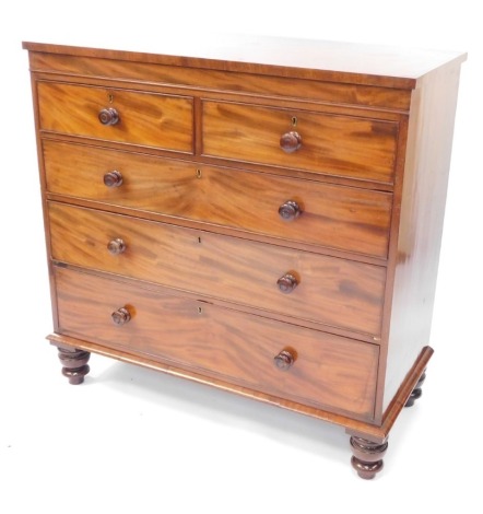 A George III mahogany chest, of two short over three long drawers, raised on turned legs, 113cm high, 114cm wide, 54cm deep.