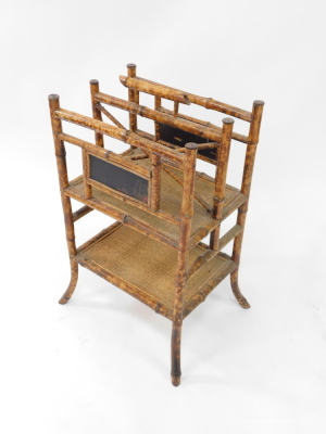 A Victorian Aesthetic period bamboo Canterbury whatnot, with inset lacquered panels, with a twin division cane bottomed upper tier, over a further cane set shelf, raised on out swept legs, 72cm high, 47cm wide, 39cm deep. - 3