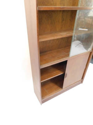 A 1960's/70s teak Gibbs Furniture bookcase, with two pairs of glass sliding doors, above a pair of doors, on a plinth, 174cm high, 92cm wide. - 2