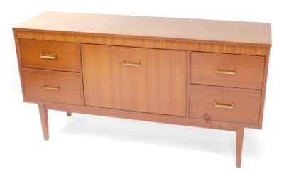 A 1960s/70s teak small sideboard cabinet, with a cross banded frieze, above a large door, flanked by two pairs of doors, on tapering feet, 74cm high, 140cm wide.