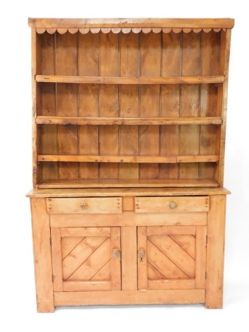 A reclaimed pine dresser, with a planked top above two frieze drawers and two paneled doors, each with turned wood handles on bracket feet, the associated plate rack with a petalated frieze, above three shelves, 198cm high, 130cm wide.