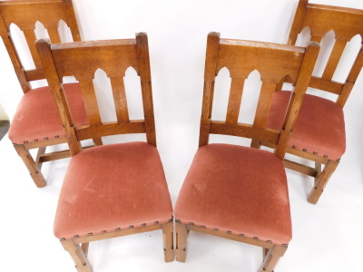 A set of four late 19thC Liberty & Co oak dining chairs, each with a Gothic shaped back, pink upholstered padded seat, on chamferred legs with H stretcher, bone labelled to underside. - 2