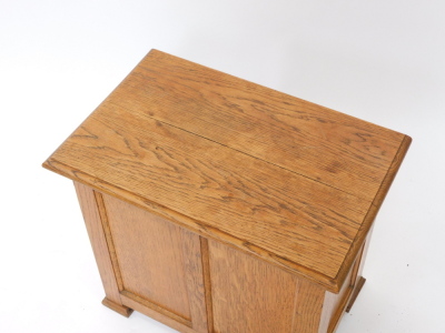 An oak Arts & Crafts workbox, the hinged lid with a moulded edge, above a paneled front on block feet, 51cm wide. - 2