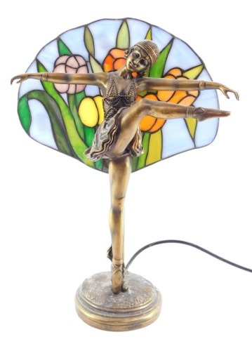 A Lorenzl style figural table lamp, modeled as an exotic dancer, with a floral stained glass back drop, 39cm high.