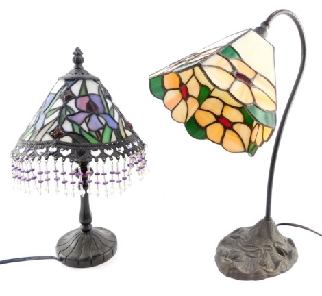 A Tiffany style desk lamp, with a pentagonal floral shade, 42cm high, and a Tiffany style table lamp, decorated to the shade with irises, with beaded frill, 36cm high. (2)