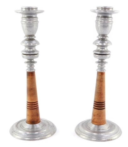 A pair of late 20thC aluminum and turned wooden candlesticks, of industrial form, 30cm high.