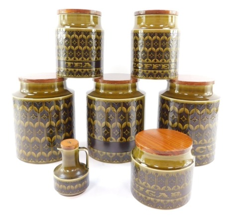 Six Hornsea pottery storage jars, with wooden lids, decorated in the Heirloom pattern, together with a vinegar bottle. (7)