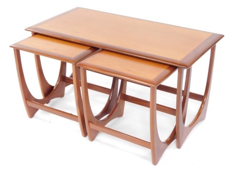 A G-Plan nest of teak occasional tables, raised on U shaped supports, largest table 51cm high, 99cm wide, 50cm deep.