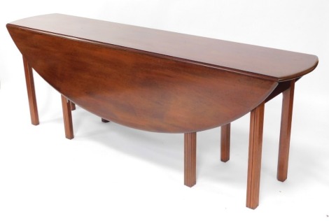 A mahogany wake table, the oval top with a moulded edge, on channeled legs, 209cm wide.