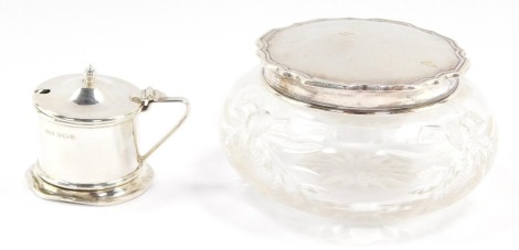 Two items of silver ware, comprising a silver mustard pot, Birmingham 1931 and a cut glass and silver topped dressing table jar, Sheffield 1931. (2)