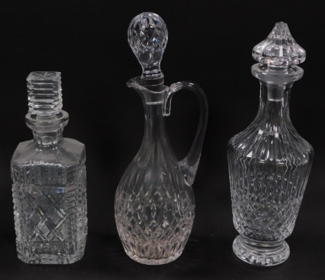 Various glassware, comprising two Waterford cut glass decanters and stoppers, a further topper, and a claret jug. (4)