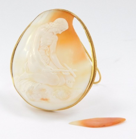 A Memento Mori shell cameo, depicting a kneeling figure aside a cross and skull, on a floral ground, within a yellow metal strut frame, stamped 9ct, 82mm high, 43.6g all in.