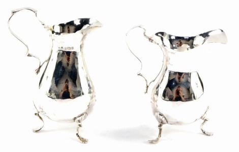 Two Edward VII silver milk jugs, with a flared rim on loop handle with tripod shell acanthus feet, Birmingham 1901, each 10cm high, 4¾oz.