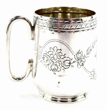 A Victorian silver christening mug, with a hammered scroll detailing and foliate decoration with oval shield bearing the initials CHI, hallmarks rubbed, possibly Birmingham 1884, 8cm high, 3½oz.