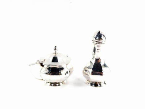 A George V silver part condiment set, comprising an octagonal pepperette, and a mustard pot with blue glass liner, Birmingham 1920, 4oz. (2)