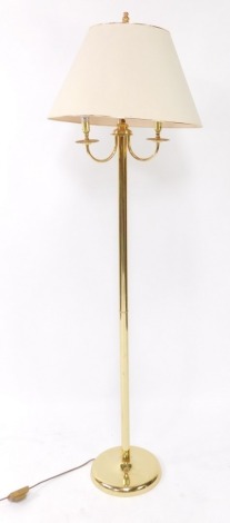 A brass effect standard lamp, with three shaped arms, on a domed foot, 170cm high.