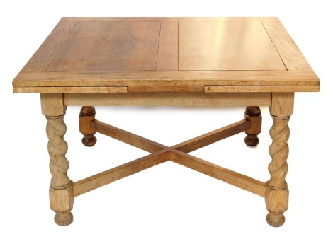 An oak extending draw leaf table, the rectangular top on spiral turned supports, with X shaped stretcher and bun feet, the top 106cm deep, 213cm long overall.