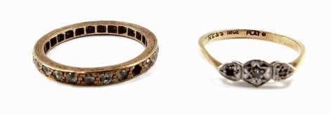 An 18ct gold platinum and diamond three stone ring, one diamond lacking, size M, 1.6g, together with a gold and gem set full eternity ring, two stones lacking, size P, 2.1g. (2)