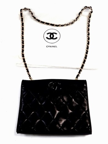 A Chanel black leather quilted shoulder bag, with logo, signature, double flap closure, internal compartment with zip fastening pocket, on a leather and chain link shoulder strap, with dust bag, 19.5cm wide.