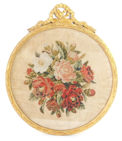 A Victorian woolwork picture decorated with flowers, within a gilt wood and gesso circular frame, 49cm wide.