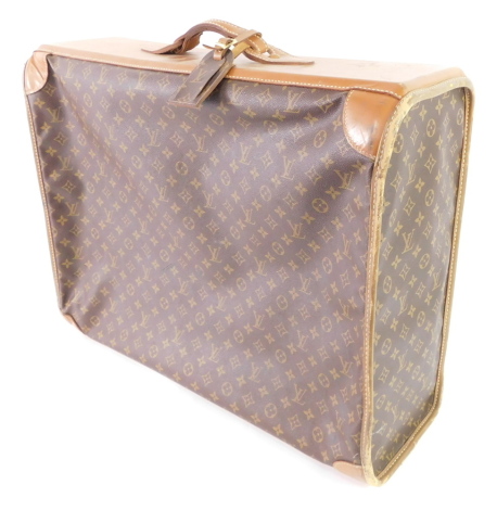 A Louis Vuitton style leather and canvas suitcase, single compartment with a side curved opening zip, 66cm wide.