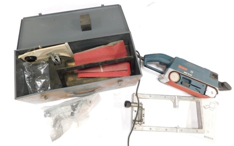 A Bosch electrical belt sander, GBS 75AE, boxed, with accessories.