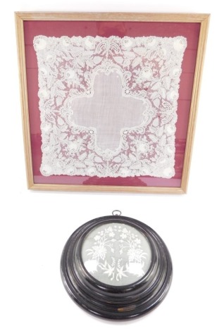 A Victorian square of lace work, probably Nottingham, decorated with flowers and leaves, framed and glazed, 31cm x 31cm., and a further piece of lace work decorated with flowers, within a circular ebonised frame, 11.5cm diameter. (2)