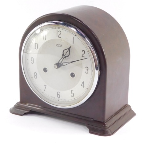 A Smiths Enfield early 20thC brown Bakelite case mantel clock, silver dial bearing Arabic numerals, eight day movement, with coil strike, the case of domed form, with key, 20cm high, 22cm wide.