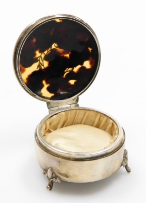 A George V silver and tortoiseshell trinket box, the circular top with tortoiseshell inlay, and applied silver detailing on a floral border, on three stylised fleur de lis feet, maker E.S.Barnsley, Birmingham 1910, 6cm diameter, 2½oz. - 2