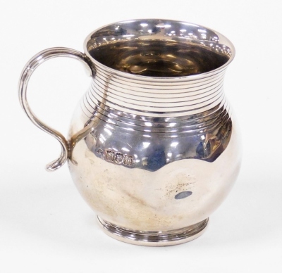 A George V silver pot bellied christening mug, bearing the initials MYP, dented, London 1927, (AF), 8cm high, 5½oz.