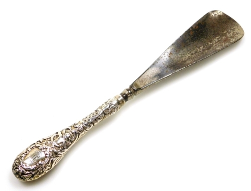 A silver handled shoe horn, bearing the initials MR, with cherub and foliate scrolling, 24cm long.