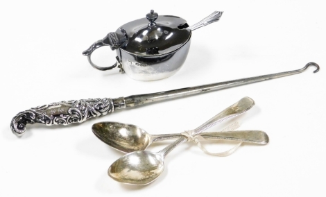 A group of silver trinkets, to include a silver mustard and spoon, Birmingham assay, two silver teaspoons, London 1900 and a silver handled button hook. (5)